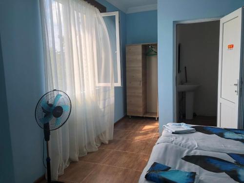 a bedroom with a fan next to a window at Отел Нана in K'obulet'i