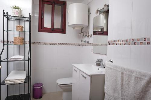 une salle de bain blanche avec toilettes et lavabo dans l'établissement Piso con garaje El Puente en Santa Cruz de La Palma, à Santa Cruz de la Palma