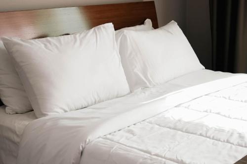an unmade bed with white sheets and pillows at Hotel Kristal in Durrës
