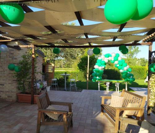 a pergola with a bunch of green balloons under it at Cascina del Poeta in Recanati