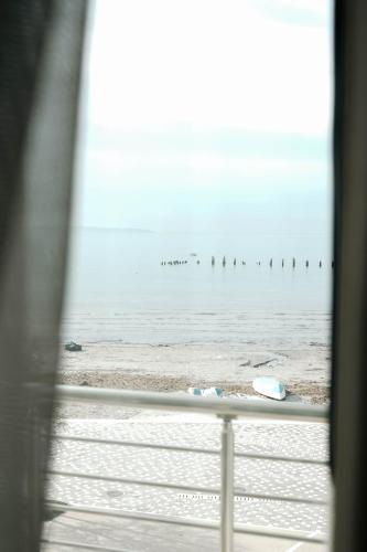 a view of the beach through a window of the ocean at Hotel Kristal in Durrës