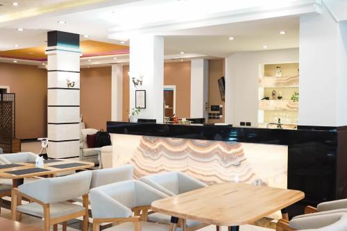 a restaurant with wooden tables and white chairs at Hotel Kristal in Durrës