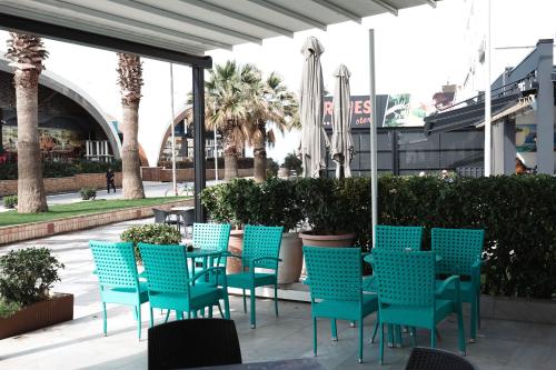 a group of blue chairs and tables on a patio at Hotel Kristal in Durrës