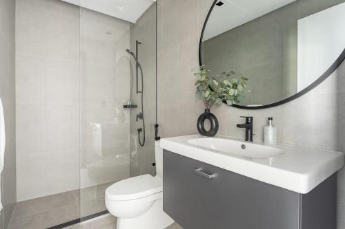 une salle de bains avec lavabo, toilettes et miroir dans l'établissement Frank Porter - 15 Northside, à Dubaï