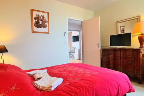 a bedroom with a red bed and a flat screen tv at Grand Appartement La Source d'Evian in Évian-les-Bains