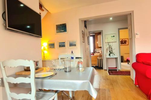 a dining room with a white table and a red couch at Grand Appartement La Source d'Evian in Évian-les-Bains