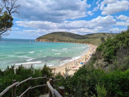 a beach with a bunch of people and the ocean at Casa Vacanze Cuore di Maremma in Il Bagno