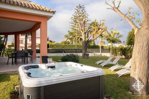 uma banheira de hidromassagem no quintal de uma casa em Villa Seaside - Beach Retreat with jacuzzi em Siracusa