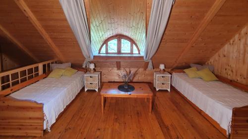 a room with two beds and a table in a cabin at Traditional cottage at Lake Balaton in Vászoly