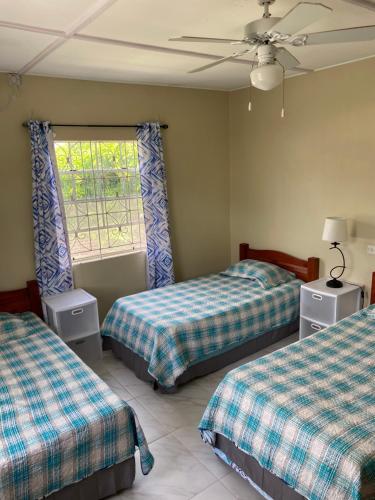 1 dormitorio con 2 camas y ventana en Darosemar, en Bridgetown