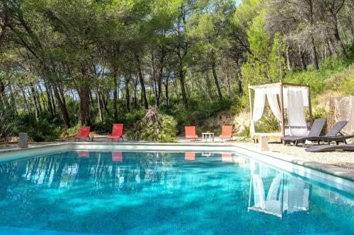 - une piscine avec des chaises, une table et des chaises dans l'établissement Bastide en pierre dans le Luberon, à Cheval-Blanc