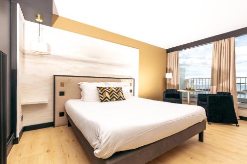 - une chambre avec un grand lit et une grande fenêtre dans l'établissement Hotel Ker Moor Saint-Quay Portrieux, à Saint-Quay-Portrieux