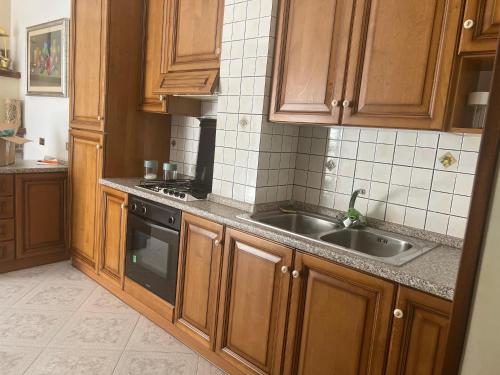 uma cozinha com armários de madeira e um lavatório em La dimora di zeus em Agerola