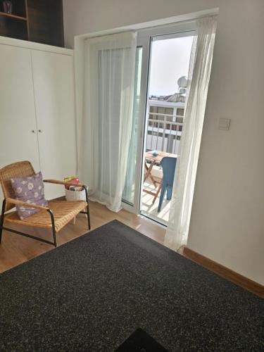 a living room with a chair and a balcony at City Center Apartments in Paphos City