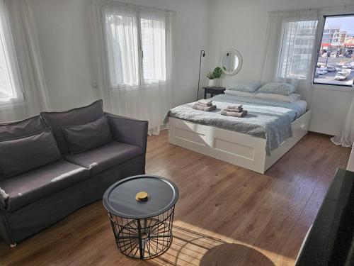 sala de estar con cama y sofá en City Center Apartments, en Pafos