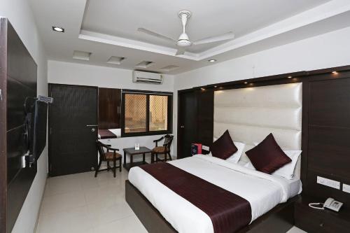 a bedroom with a large bed and a table at Hotel Franklein Stay At Delhi Airport in New Delhi
