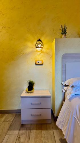 a bedroom with a bed and a nightstand with plants on it at Domus Angeli in Assisi
