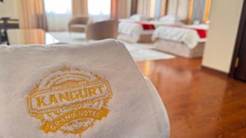 a towel with the name of kaminut sitting on a chair at Kangurt Grand Hotel in Dushanbe