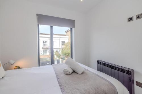 een witte slaapkamer met een groot bed en een raam bij Super Central 2 Bedroom Flat I Next to Brighton Station in Brighton & Hove