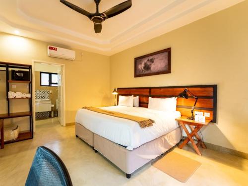 1 dormitorio con 1 cama y ventilador de techo en The Shrub Lodge en Victoria Falls
