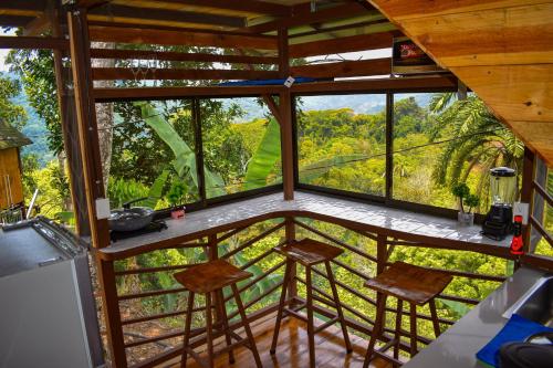 a view from the kitchen of a tree house with stools at Finca Makambu in Platanillo