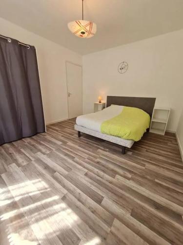 une chambre avec un lit et un parquet dans l'établissement Appartement accueillant à Rosureux 70 m² avec jardin partagé, à Rosureux