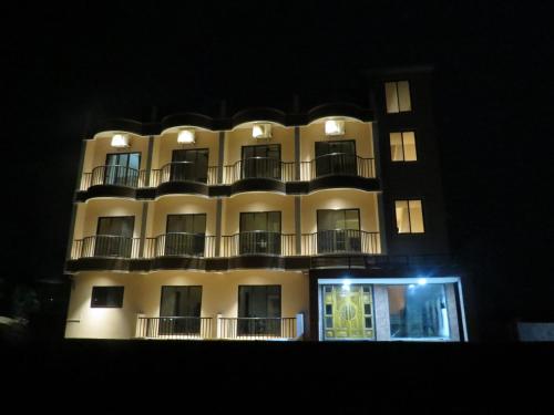 a tall building with balconies on it at night at SV Inns Sea Pearl in Devgarh