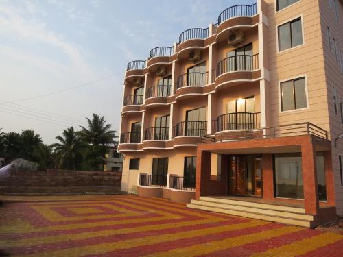 a building with balconies on the side of it at SV Inns Sea Pearl in Devgarh