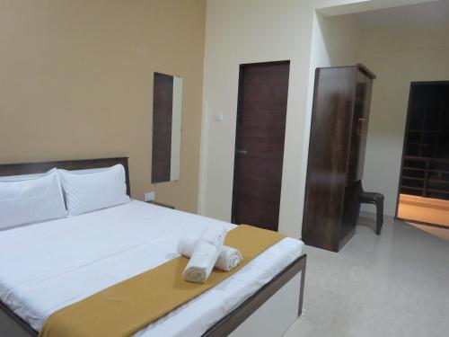 a bedroom with a bed with a towel on it at SV Inns Sea Pearl in Devgarh