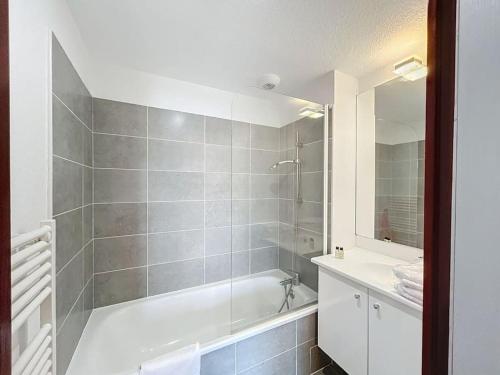 een badkamer met een bad, een wastafel en een spiegel bij 3303 - maison avec piscine in Argelès-sur-Mer