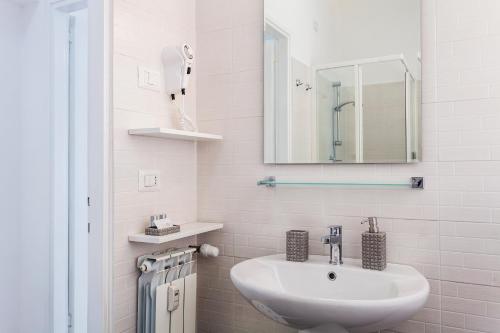 bagno bianco con lavandino e specchio di St Peter Lodge a Roma