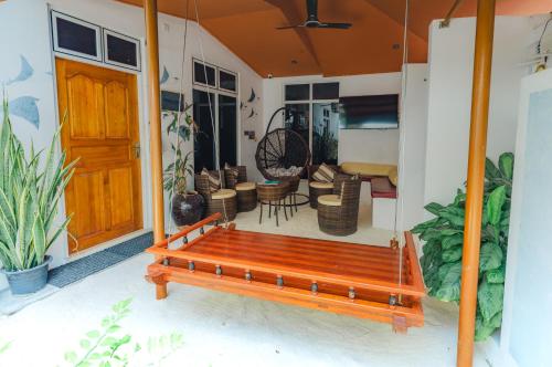 a wooden bench sitting on the front porch of a house at Karanka Villa @ Mahibadhoo in Mahibadhoo