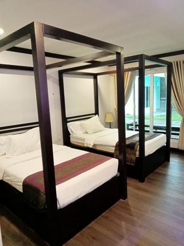 two beds in a room withthritisthritislictslictslicts at Twin Palms Resort in Sihanoukville
