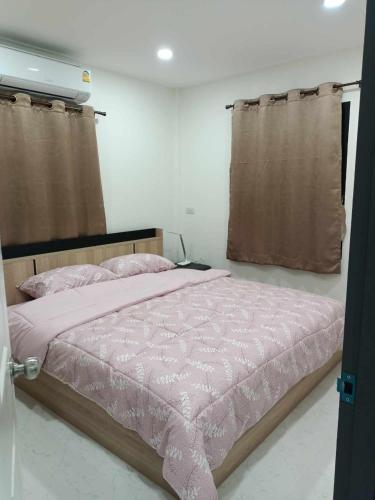1 dormitorio con 1 cama con edredón rosa en ๋Jenny resort 43/8, en Nong Prue