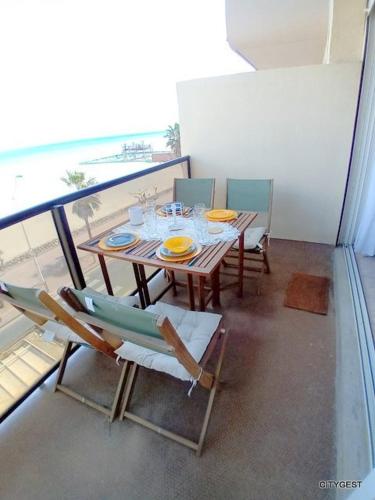 Cette chambre dispose d'un balcon avec une table et des chaises. dans l'établissement Studio vue mer, ascenseur, parking - 4NOUM11, à Canet