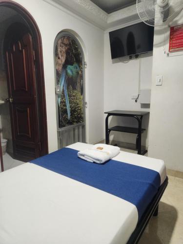 a bedroom with a bed and a table in a room at Hotel Manoa in Cúcuta