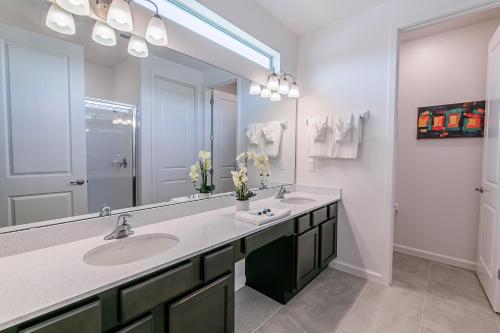 a bathroom with two sinks and a large mirror at StarWar Retreat 3D 12BR 11.5BA Villa Pool BBQ in Kissimmee