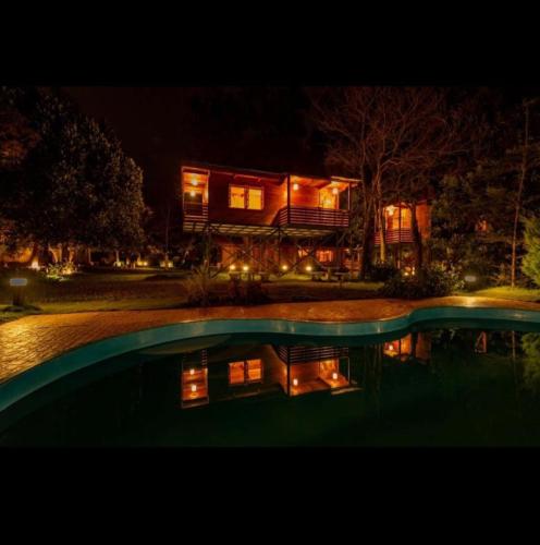 a house at night with a pool in front of it at La serene nandihills in Nandi