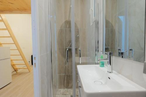 une salle de bain blanche avec un lavabo et une douche dans l'établissement Le Pinky Bird - Vitry sur Seine, à Vitry-sur-Seine