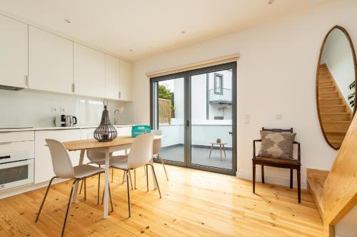 a kitchen and dining room with a table and chairs at Belem Design Apartments by Homing in Lisbon