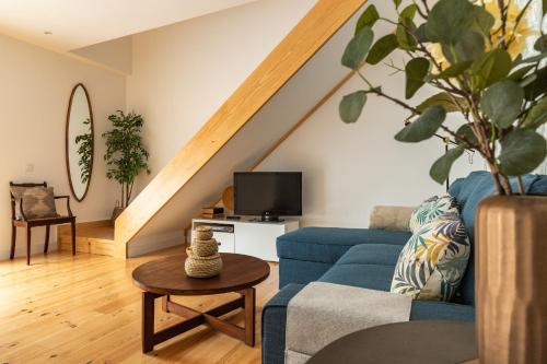 a living room with a blue couch and a tv at Belem Design Apartments by Homing in Lisbon