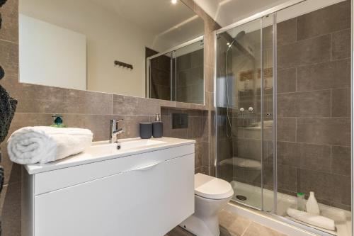 a bathroom with a shower and a sink and a toilet at Belem Design Apartments by Homing in Lisbon