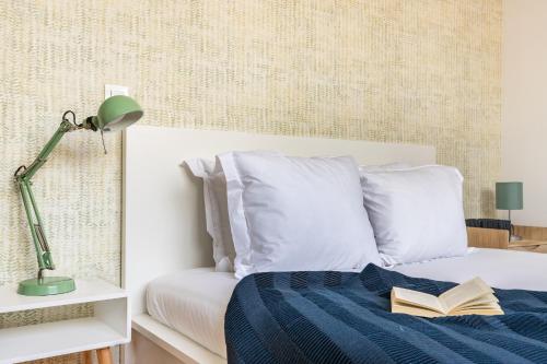a bedroom with a bed with a book on it at Belem Design Apartments by Homing in Lisbon