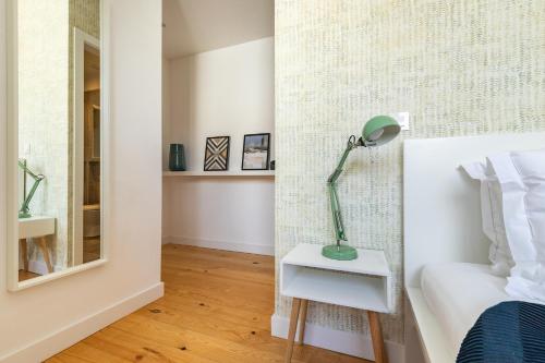 a bedroom with a bed and a lamp on a night stand at Belem Design Apartments by Homing in Lisbon