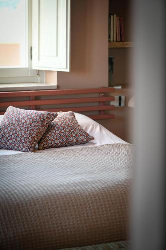 a bed with two pillows on it in a bedroom at Antica Masseria le Monache in Grottaglie