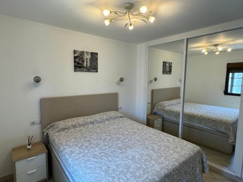 een slaapkamer met een bed en een spiegel bij Sea View Apartment in Manilva