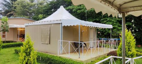 a small house with a tent in a yard at La serene nandihills in Nandi
