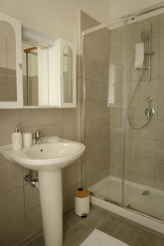 a white bathroom with a sink and a shower at B&B SARDES in Cervaro