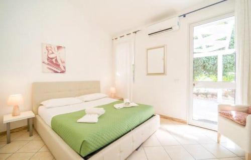 マリネッラにあるIl giardino di Afroditeのベッドルーム1室(大型ベッド1台、緑の毛布付)