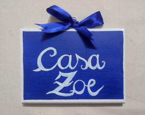 a blue sign with a blue bow on a wall at Casa Zoe in Piacenza